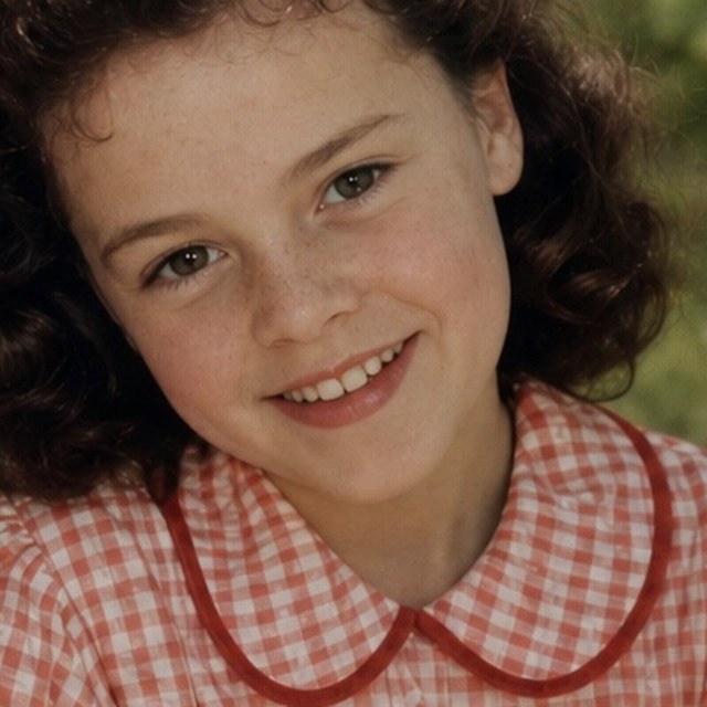 Zoomed detail of the daughter’s smile and checked dress after restoration
