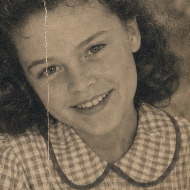 Zoomed detail of the daughter’s smile and checked dress before restoration